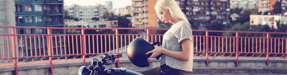 Mujer subida en una moto poniéndose un casco