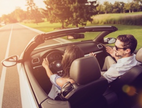 Mujer conduciendo un coche junto a su pareja