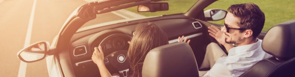 Mujer conduciendo un coche junto a su pareja